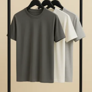 Three premium cotton crew neck t-shirts in charcoal, off-white, and light grey hanging on black hangers.